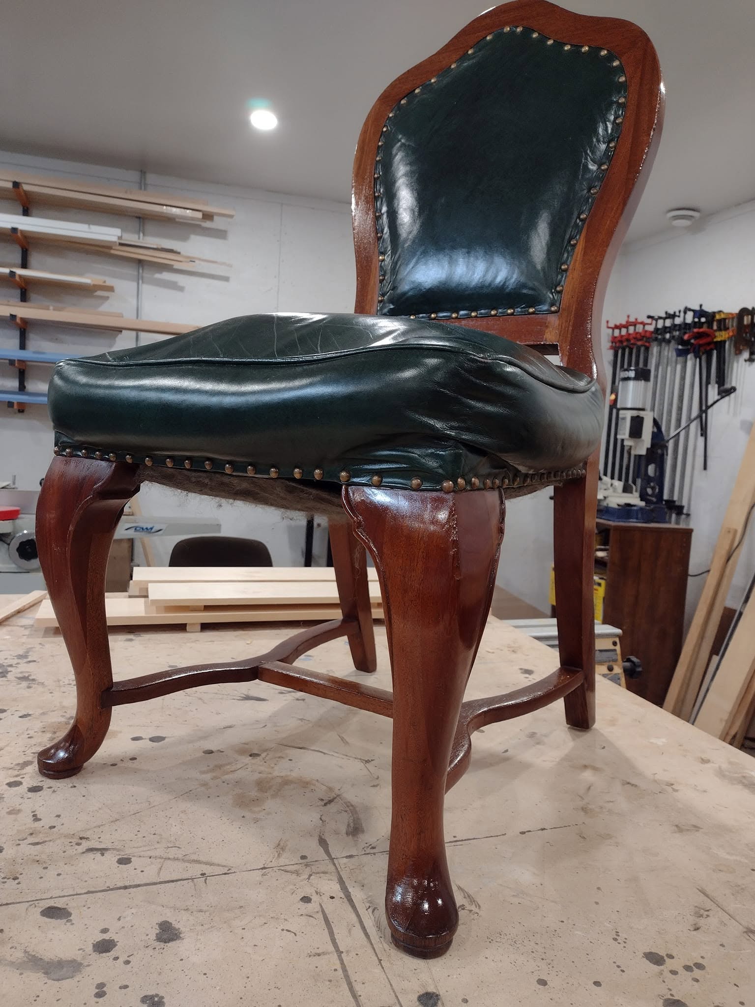 Restored antique chair with green leather upholstery
