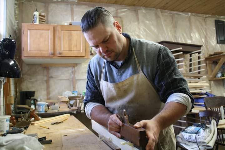 Matt Collicott using a wooden hand plane at the workbench